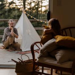 little-kid-in-armchair-looking-at-father-sitting-near-wigwam-3932958